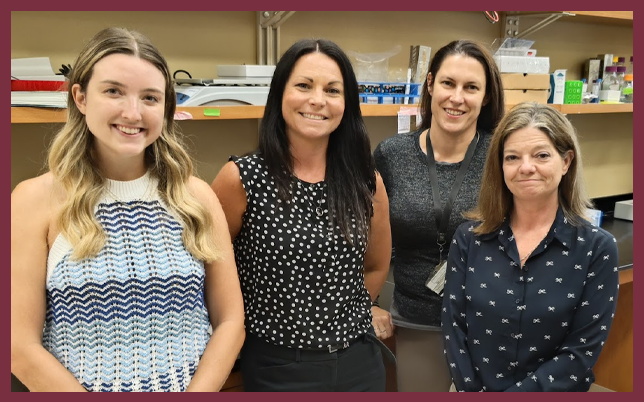 Four women smiling together in the McCarthy laboratory.