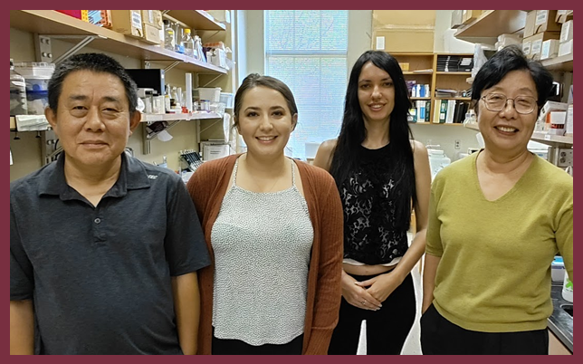 Four individuals standing together in the Zhou laboratory.