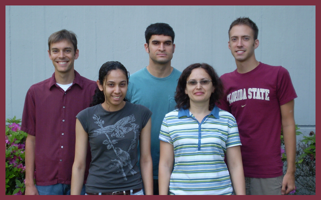A group photo of five Brian Miller lab members standing in two rows against a grey wall.