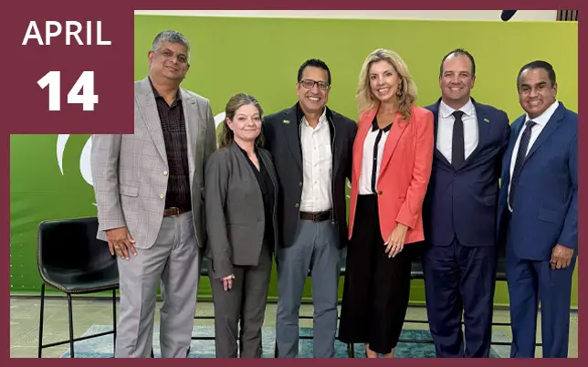 Six professionals stand in a row for a group photo in front of a green backdrop with a calendar graphic in the upper left corner marking April 14.