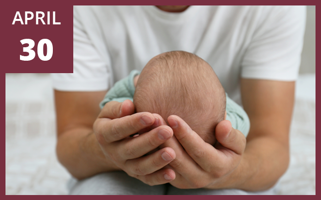 A person in a white shirt holds a newborn baby's head in their hands, with a calendar overlay reading April 30.